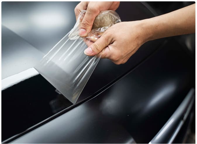 Protective film being applied to a vehicle panel